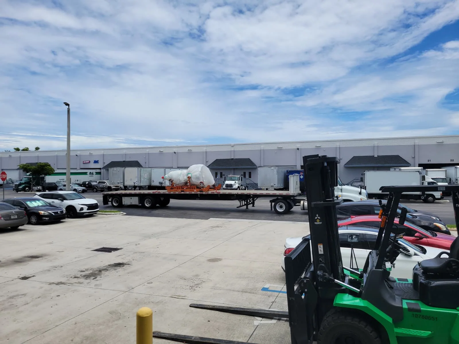 Wrapped large component on a trailer outside a warehouse.