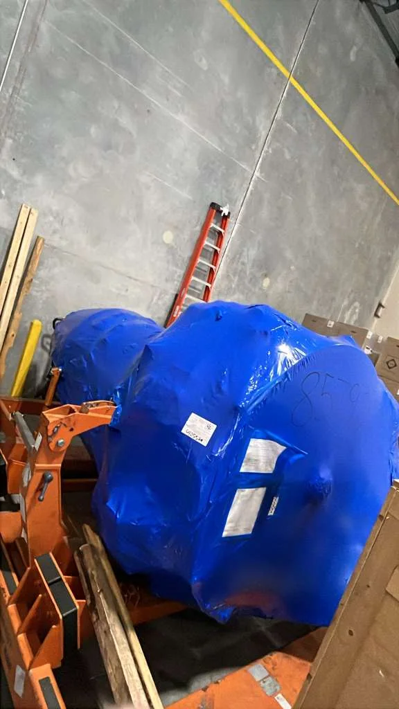 Close view of blue protective wrapping around a large component.