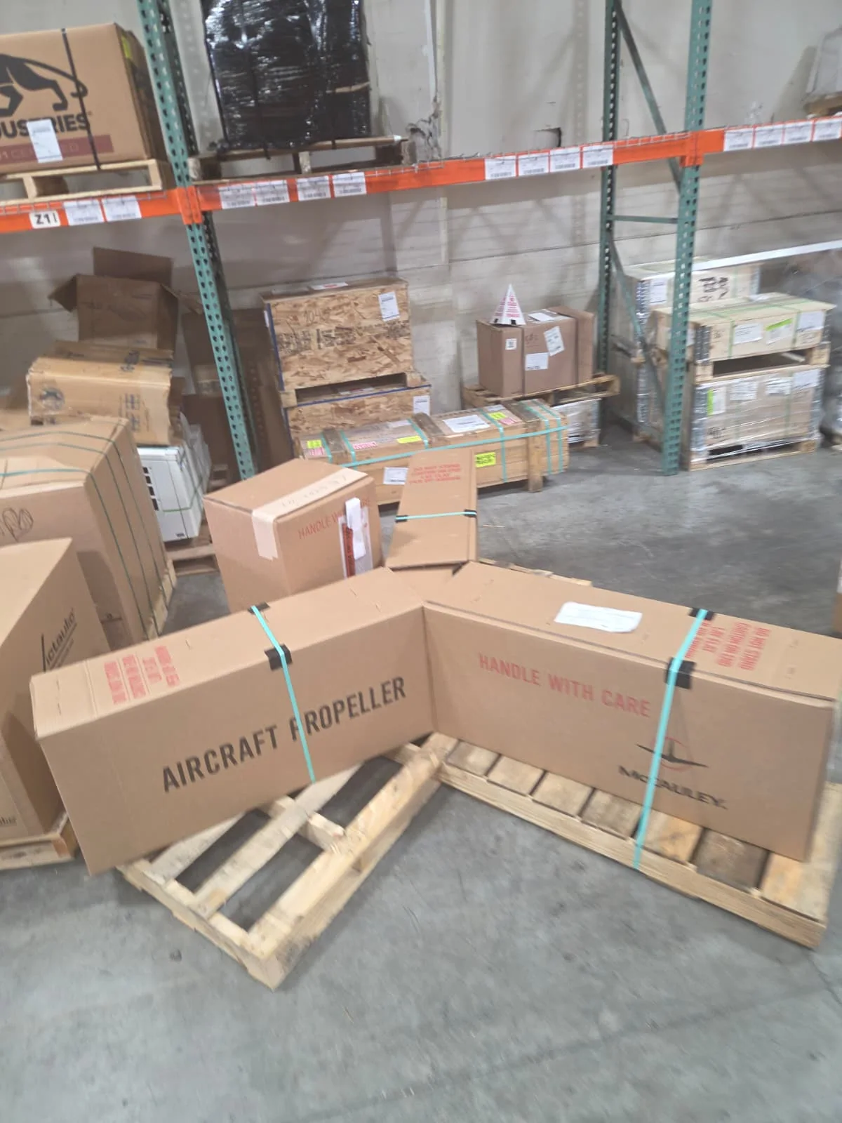 Close view of propeller packages and surrounding warehouse cargo.