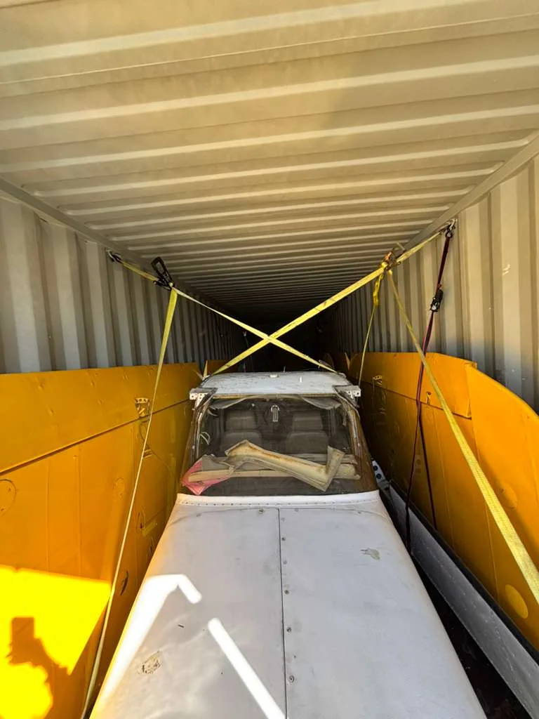 Lengthwise view of the small aircraft secured in the container.
